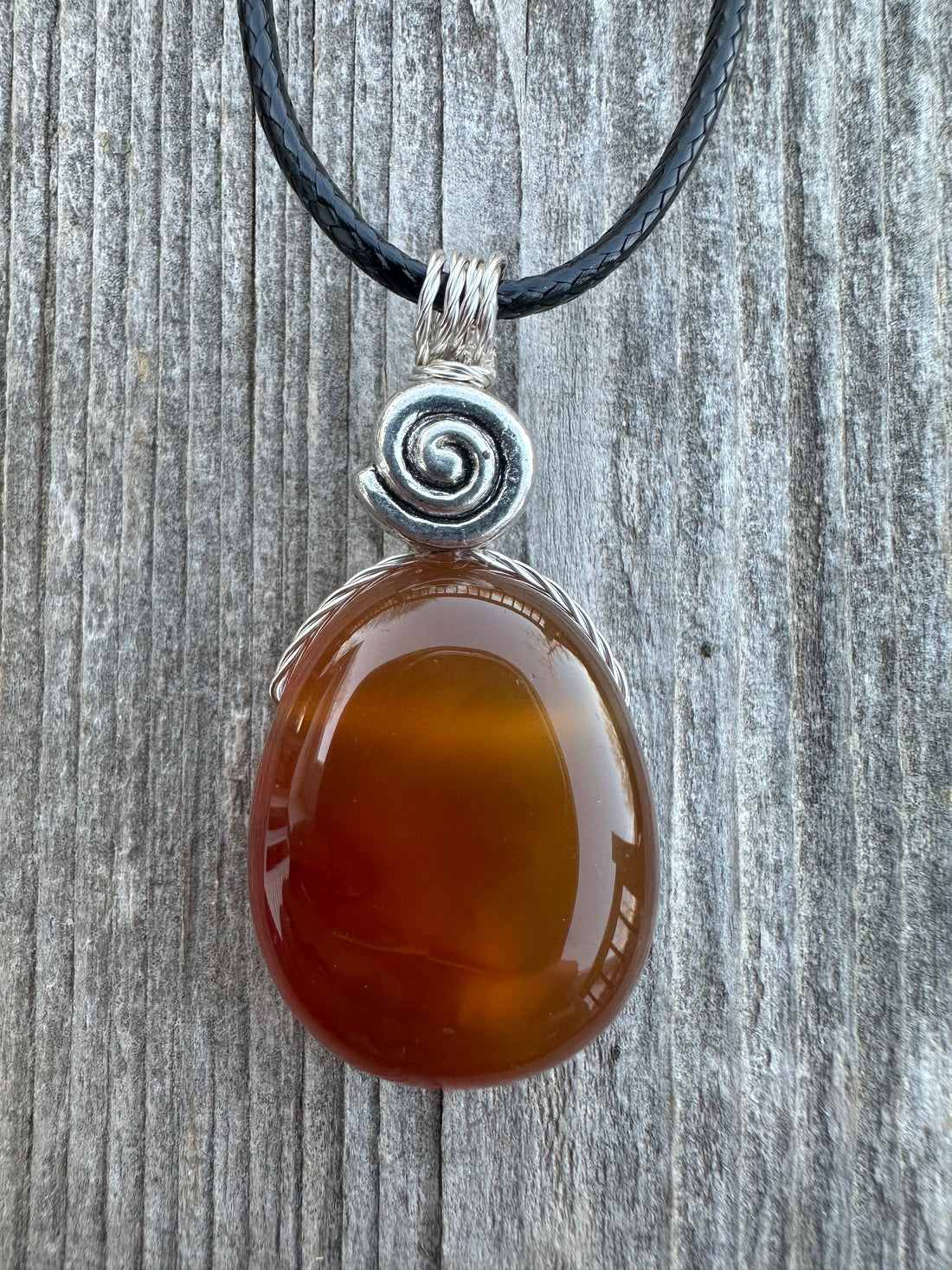 Carnelian for Courage, Success and Creativity. Swirl to Signify Consciousness.