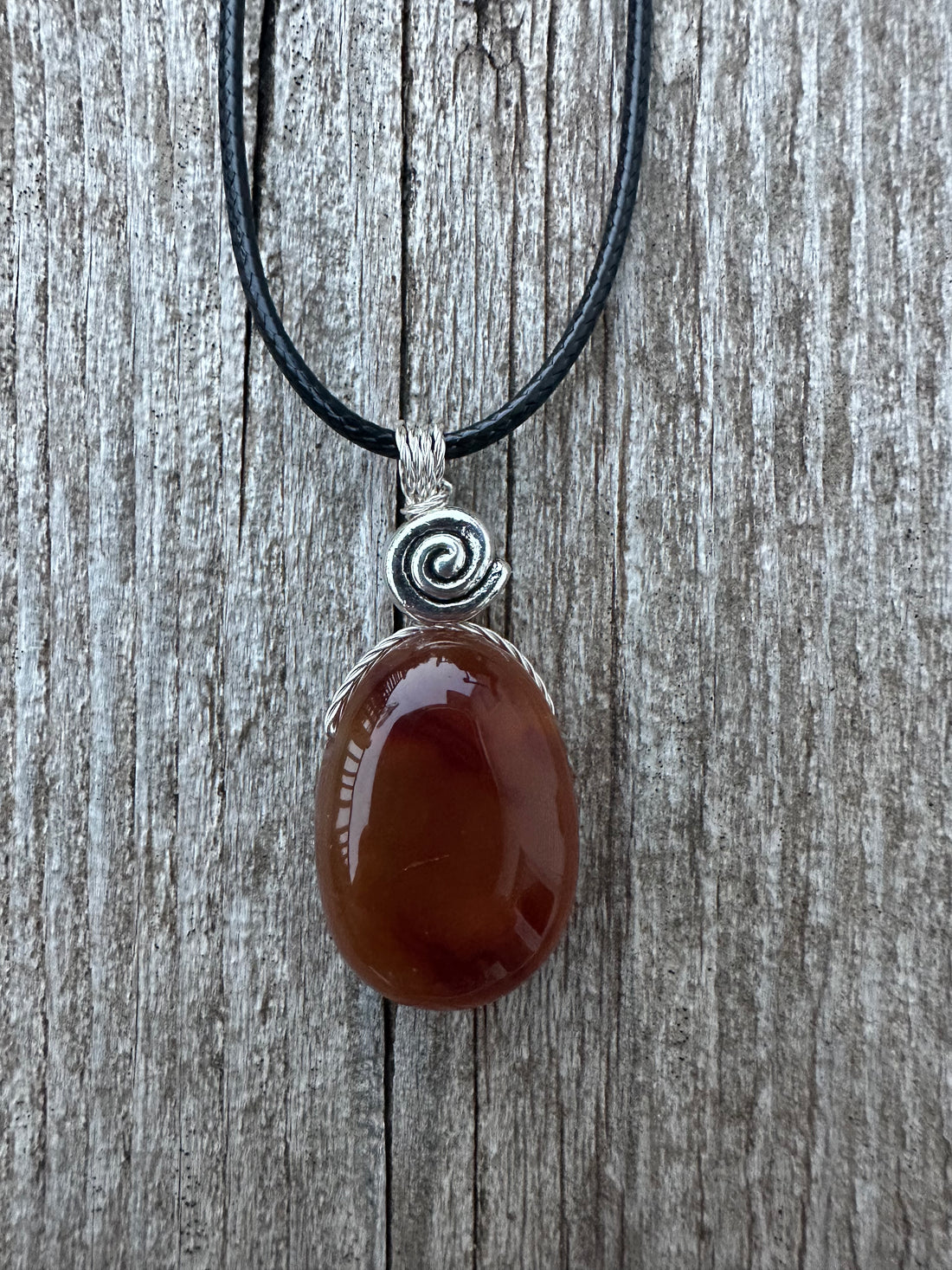 Carnelian for Courage, Success and Creativity. Swirl to Signify Consciousness.