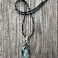 Emerald for Awareness, Love and Wisdom. Swirl to Signify Consciousness. 18 inch Cable.